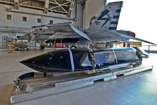 Naval defense missile in hangar with Navy aircraft — Trident Industries aerospace and naval work