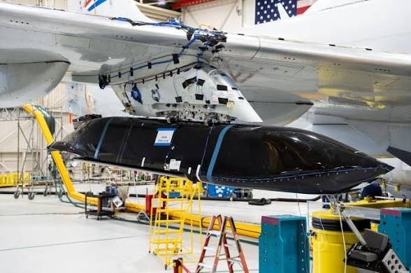 Missile loaded under aircraft wing in hangar