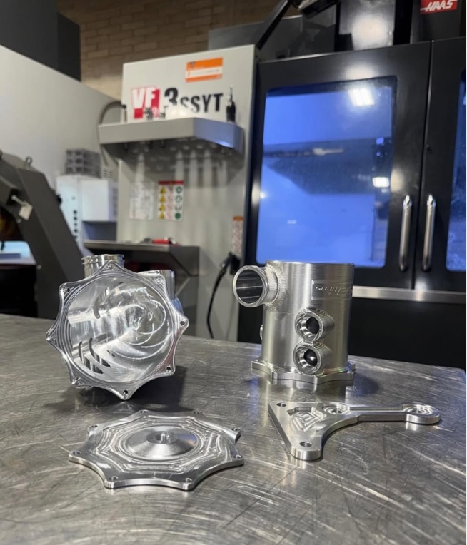 Trident Industries CNC machining facility with Haas VF3 machine and precision parts